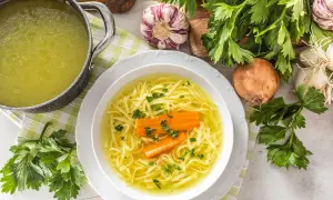 Aromaticzny rosół z makaronem i marchewką, podany w białej misce. Czy rosół jest lekkostrawny? Tak, to idealna, rozgrzewająca potrawa.