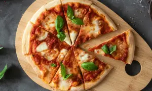 Margherita pizza na drewnianej desce, idealna na szybki przepis na ciasto do pizzy. Świeża bazylia dodaje aromatu.