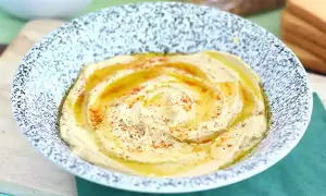 Pyszny, kremowy hummus w misce, polany oliwą i posypany papryką. Idealny do pieczywa, jako część zdrowego posiłku. Ten przepis na hummus jest prosty!