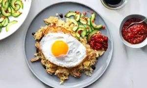 Pyszny ryż smażony z jajkiem sadzonym, ogórkiem i pikantnym sosem. Idealny posiłek nasi.