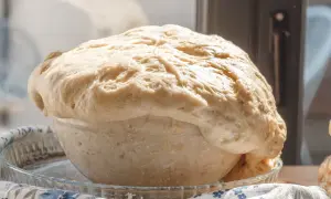 Wyrośnięte ciasto drożdżowe w szklanej misie, gotowe do pieczenia. Idealne na ciasto drożdżowe przepis.