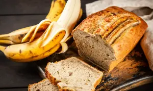 Pyszne, wilgotne ciasto bananowe, które zawsze się udaje. Obok leżą dojrzałe banany, gotowe do pieczenia.
