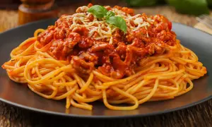 Pyszne spaghetti bolognese z mielonym mięsem, polane sosem pomidorowym i posypane serem. Idealne pytanie: jakie mięso do spaghetti?