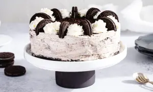 Pyszny sernik Oreo, ozdobiony bitą śmietaną i ciasteczkami. Idealny przepis na deser!