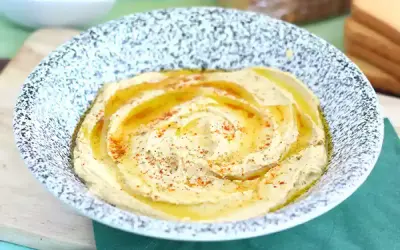 Pyszny, kremowy hummus w misce, polany oliwą i posypany papryką. Idealny do pieczywa, jako część zdrowego posiłku. Ten przepis na hummus jest prosty!