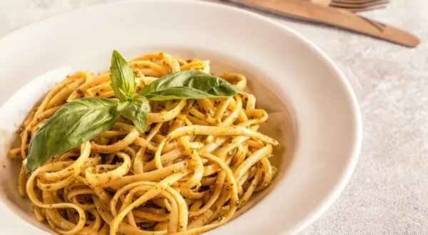 Pyszne linguini z pesto i świeżą bazylią, gotowe do podania.