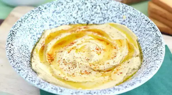 Pyszny, kremowy hummus w misce, polany oliwą i posypany papryką. Idealny do pieczywa, jako część zdrowego posiłku. Ten przepis na hummus jest prosty!