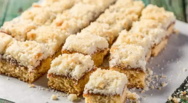 Szybkie ciasto na niedzielę do kawy, pokrojone w kostkę, z warstwą dżemu i kruszonką. Idealne na leniwe popołudnie.
