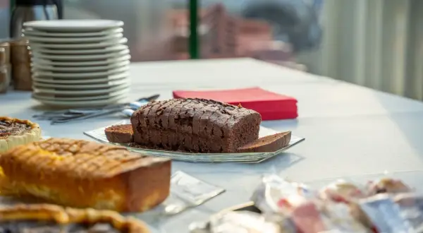 Szybkie łatwe ciasto z powidłami, czekoladowy bochenek pokrojony w plastry, obok babeczki i złocisty keks.