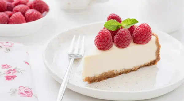 Pyszny sernik z malinami i miętą, idealny na deser. Zastanawiasz się nad sernik kcal? Ten wygląda kusząco!