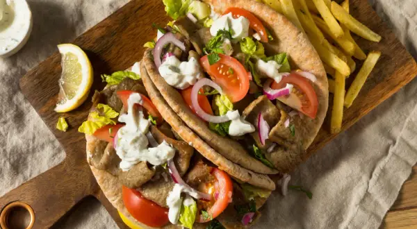 Klasyczny gyros przepis: soczyste mięso, świeże warzywa i sos czosnkowy w picie, podane z chrupiącymi frytkami. Idealny na szybki obiad.