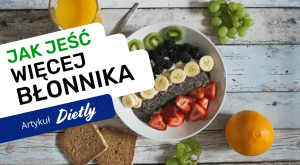 Pyszna owsianka z owocami i nasionami chia – idealna na śniadanie, które ma dużo błonnika. Obok pomarańcza, winogrona i chleb pełnoziarnisty.