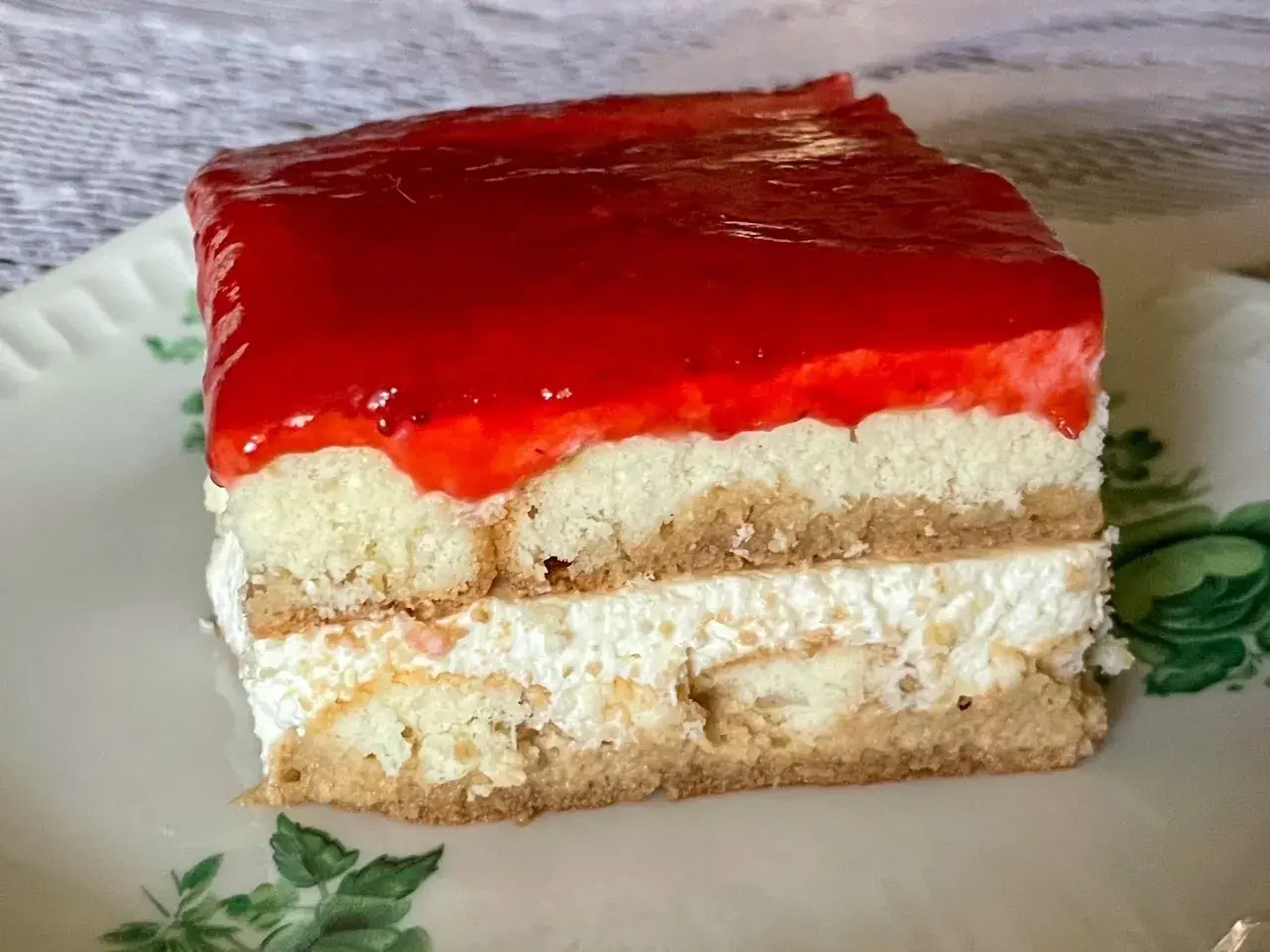 Pyszne, mega szybkie ciasto bez pieczenia z warstwami biszkoptu, kremu i truskawkową galaretką. Idealne na deser!