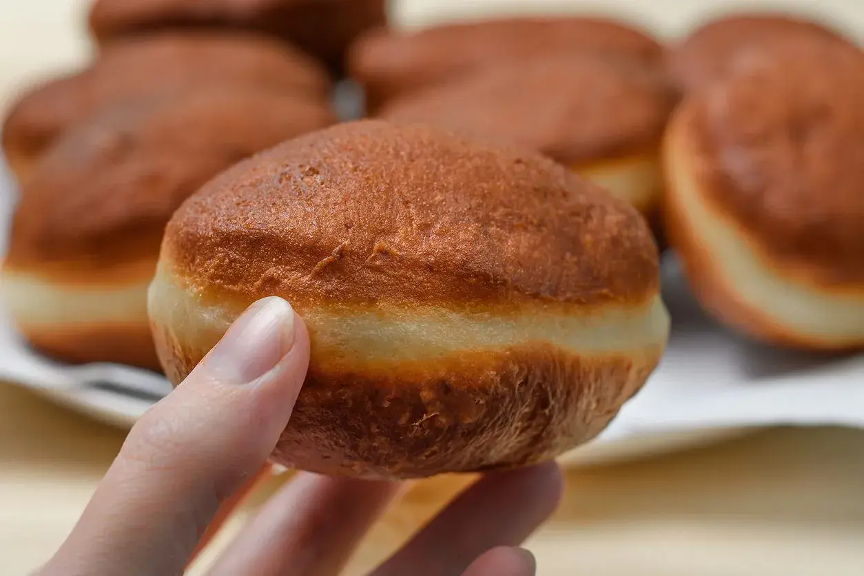 Puszyste pączki, jak ze starego przepisu, gotowe do nadzienia. Delikatna skórka i jasny środek.