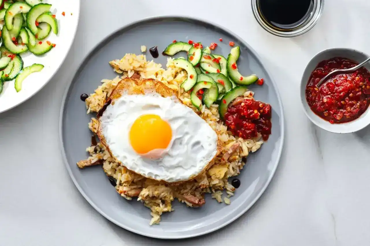 Pyszny ryż smażony z jajkiem sadzonym, ogórkiem i pikantnym sosem. Idealny posiłek nasi.