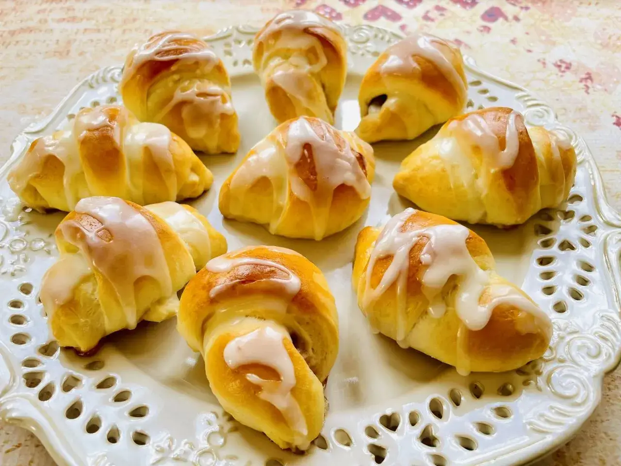 Mięciutkie rogaliki drożdżowe przepis. Pyszne, domowe rogaliki z lukrem na ozdobnej tacy.