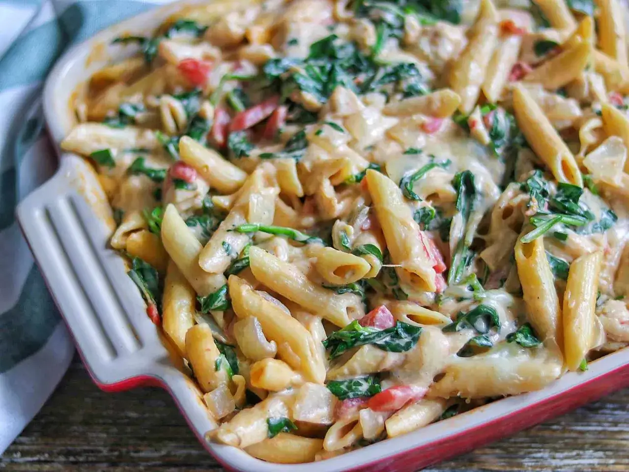 Penne w kremowym sosie ze szpinakiem i kurczakiem, zapiekane w naczyniu. Pyszne danie, które zachwyci każdego.