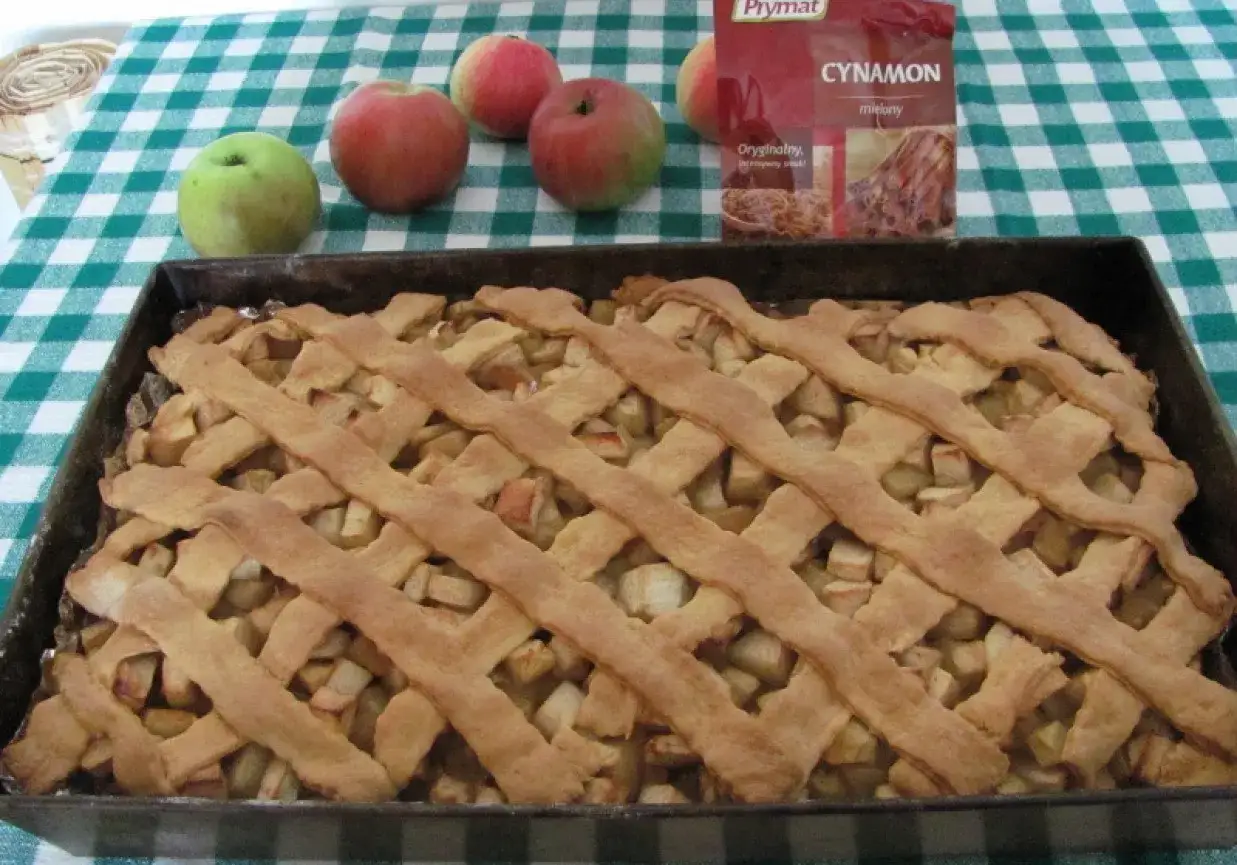 Klasyczna szarlotka na kruchym cieście, z jabłkami i cynamonem, gotowa do pieczenia.