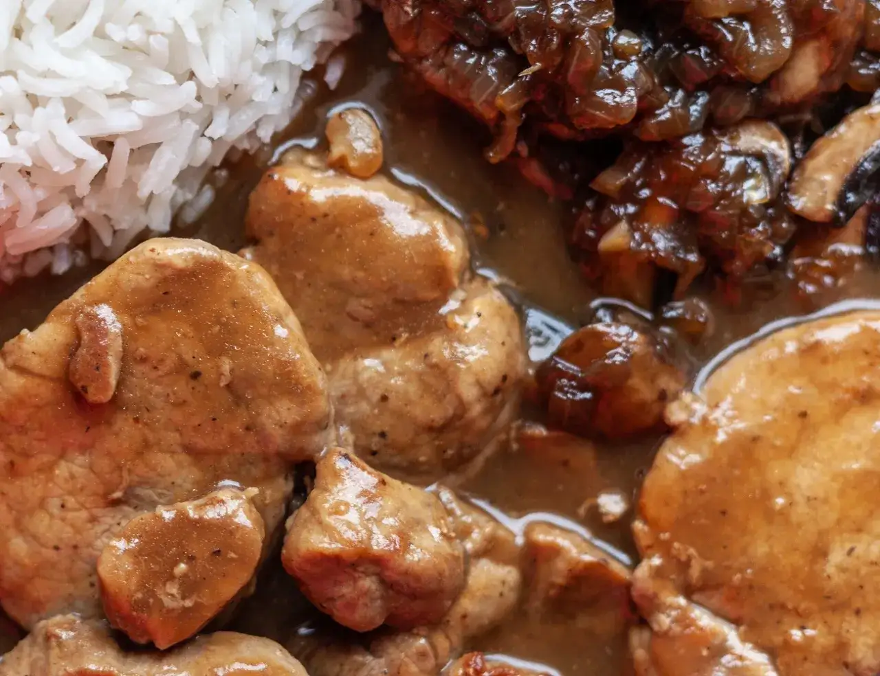 Pyszny sos do mięsa z pieczarkami i cebulką, podany z ryżem. Idealny przepis na obiad.