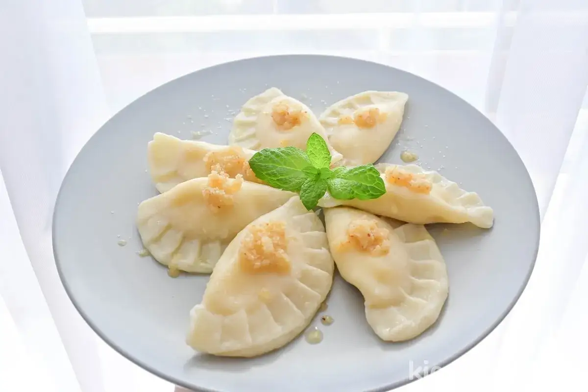 Pyszne pierogi z mięsem, udekorowane miętą. Idealne, gdy zastanawiasz się, ile gotować pierogi, by były idealne.